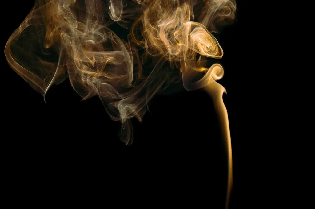 Gold smoke rising on black